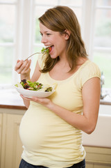 Schwangere isst Salat.