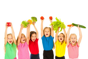 Gruppe von Kindern hält Gemüse in die Höhe