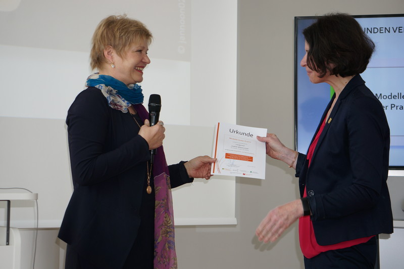 Karin Schindler übergibt Heidemarie Hell vom Projekt Vitalküche und H2NOE-Wasserschule ihre Urkunde.