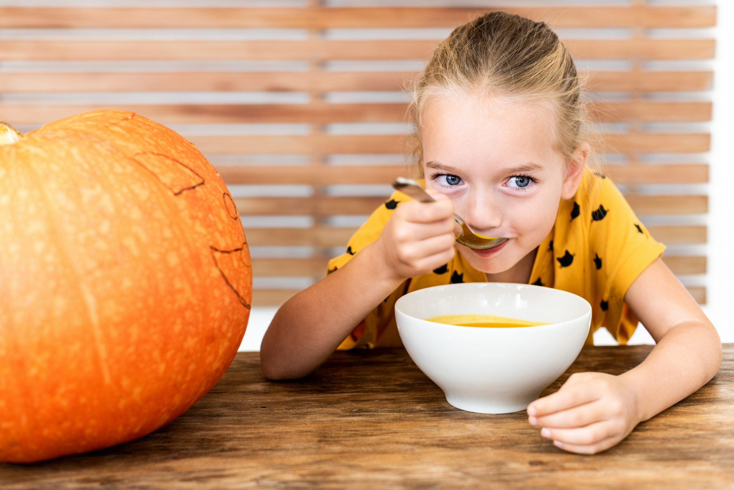 Kind isst Kürbissuppe