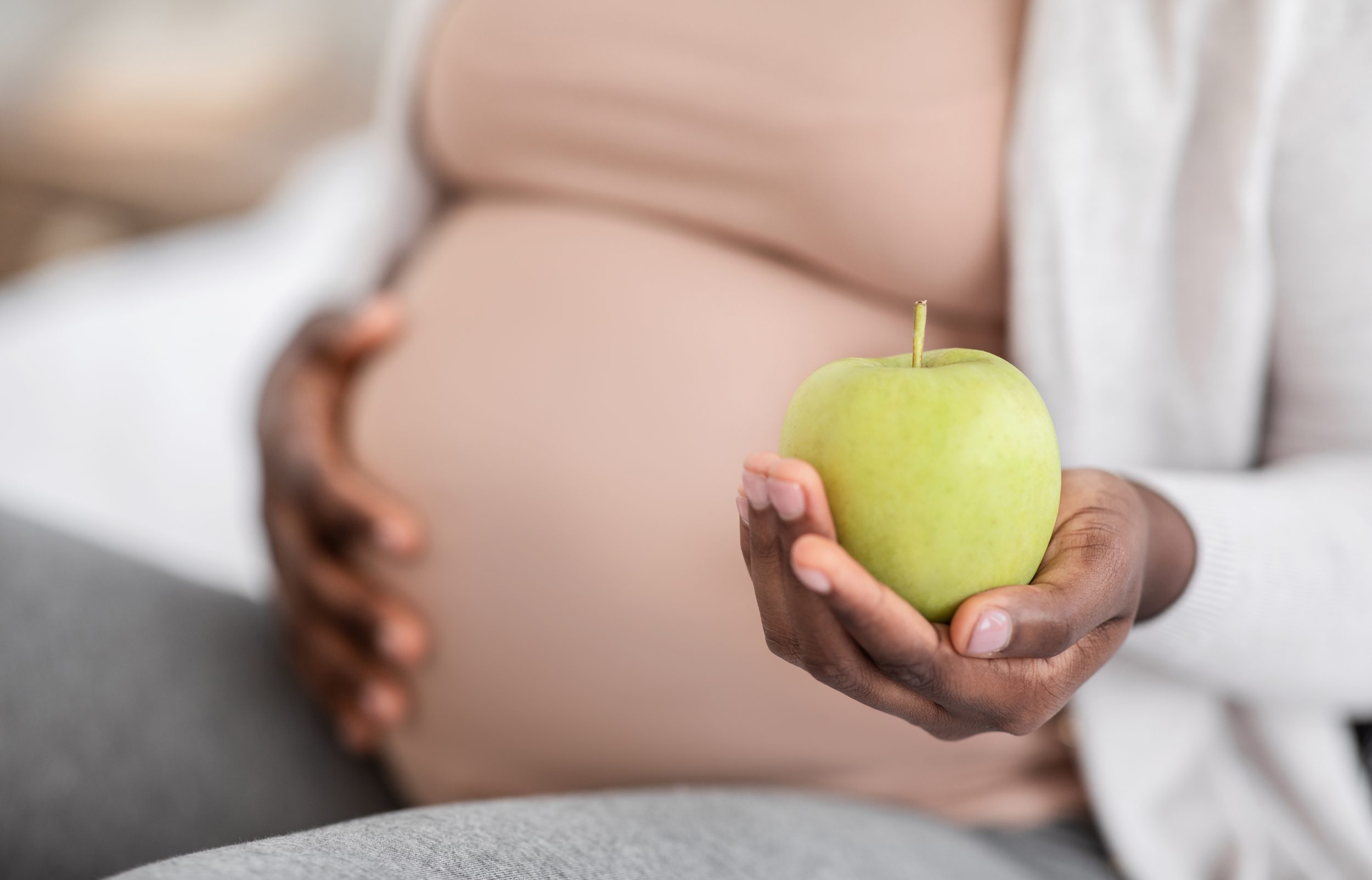 Schwangere Frau mit Apfel