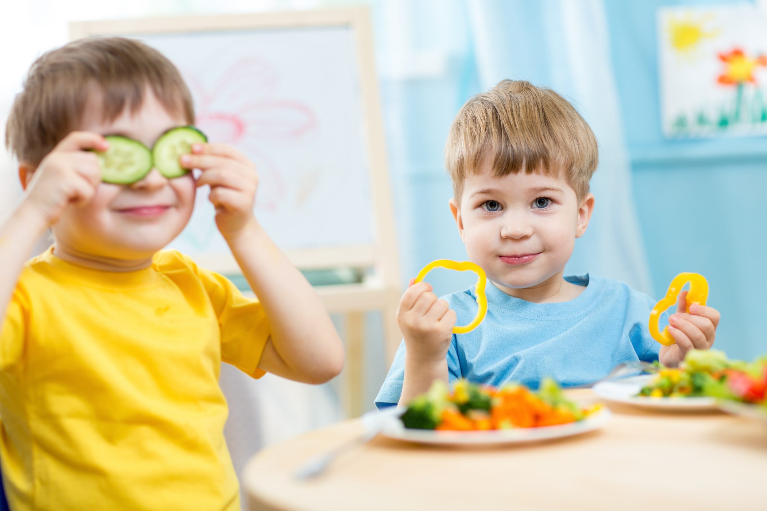 Kinder spielen mit Gemüse