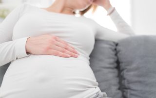 Schwangere greift sich auf den Bauch