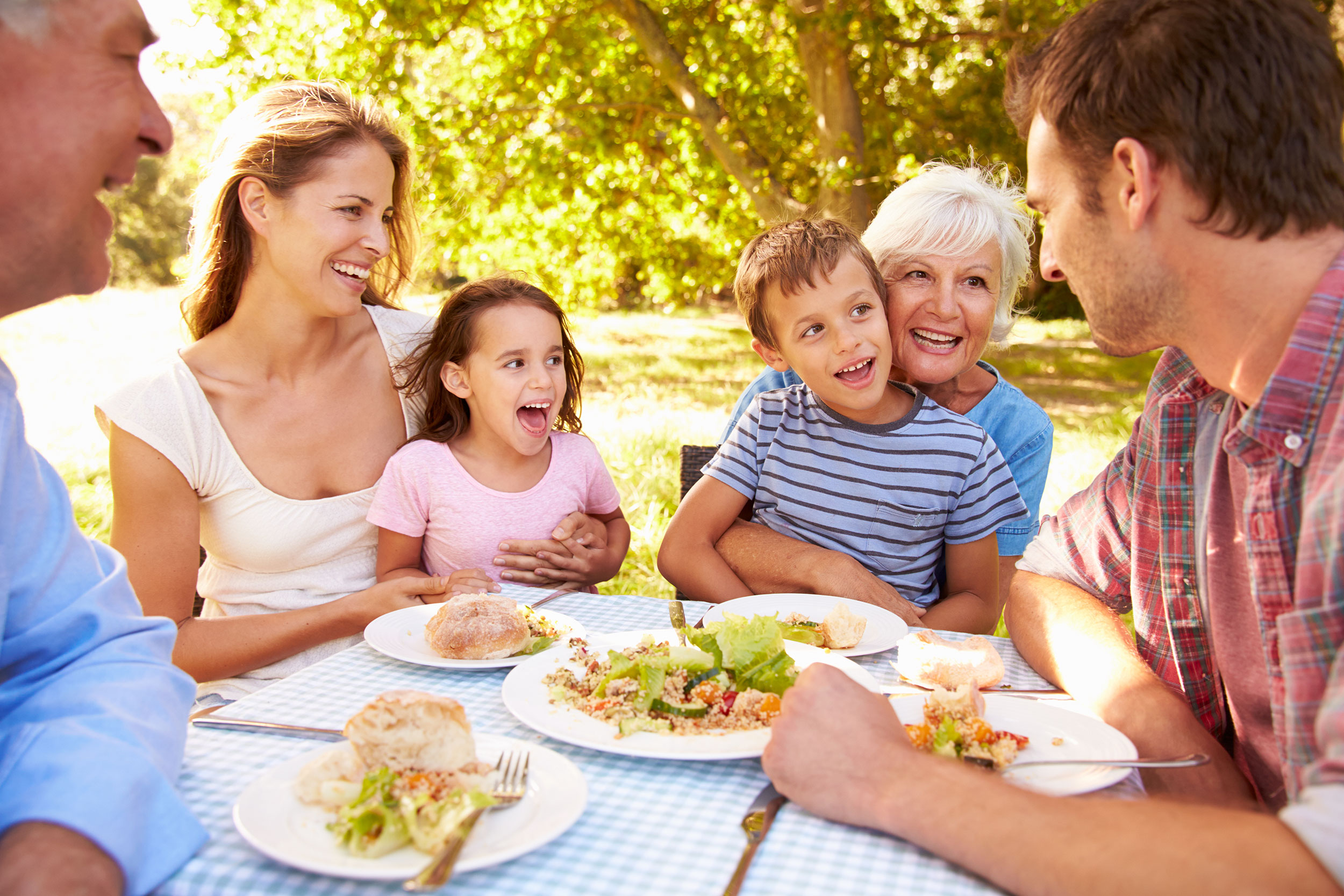 Familie sitzt bei Tisch und isst